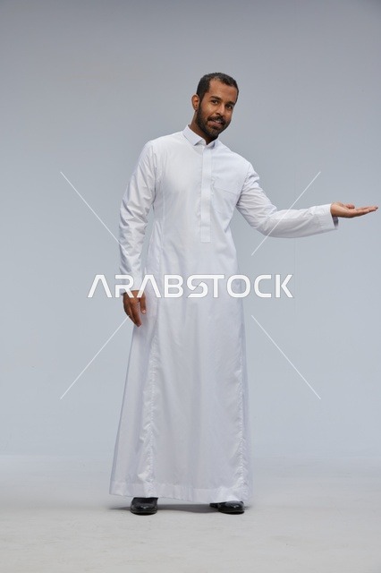 Saudi Man in White Thobe Presenting on Studio Background