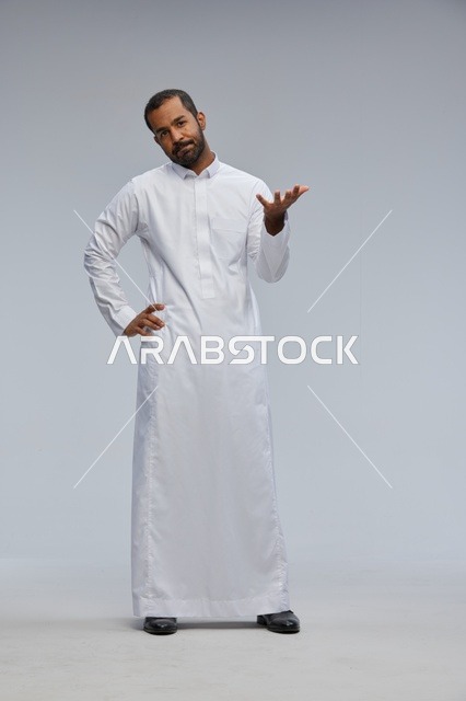 رجل سعودي يرتدي الثوب الأبيض يشير بيده في الاستوديو