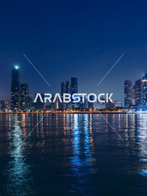 أفق مدينة الدوحة في قطر ليلاً مع انعكاسات المياه