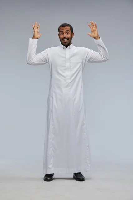 رجل سعودي بالثوب الأبيض يرفع يديه بتعابير مندهشة