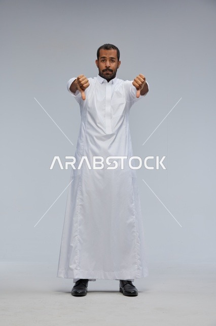 رجل سعودي يرتدي ثوباً أبيض يشير بالرفض