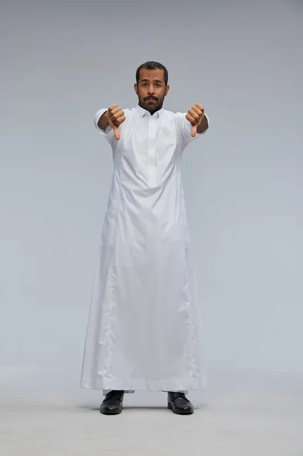 رجل سعودي يرتدي ثوباً أبيض يشير بالرفض