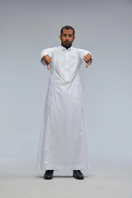 رجل سعودي بالثوب الأبيض يشير بعلامة الرفض