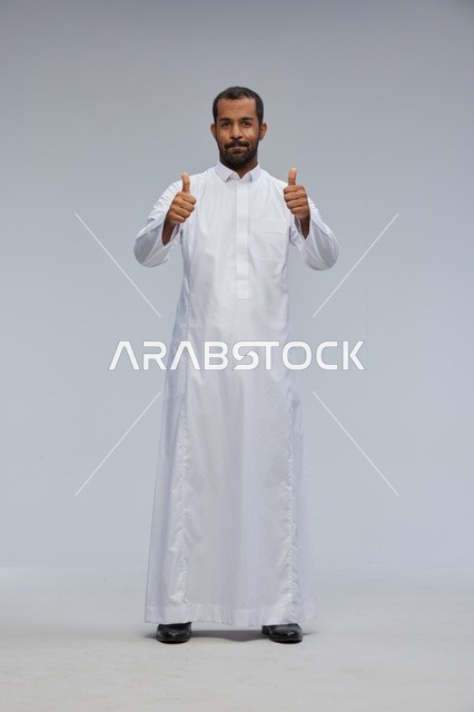 رجل سعودي بالثوب الأبيض يرفع إبهامه علامة للنجاح