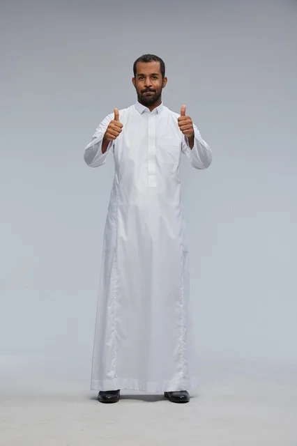 رجل سعودي بالثوب الأبيض يرفع إبهامه علامة للنجاح
