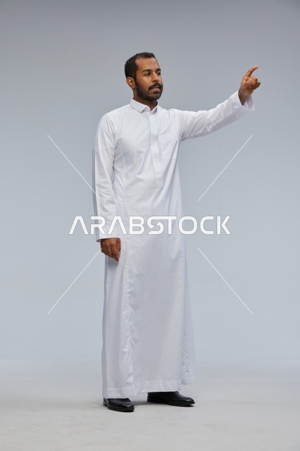 Saudi Man in White Thobe Pointing at Virtual Interface