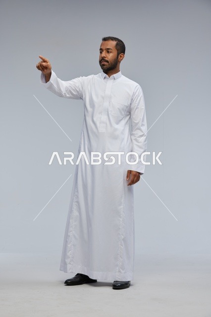 Saudi Man in White Thobe Pointing at Virtual Screen