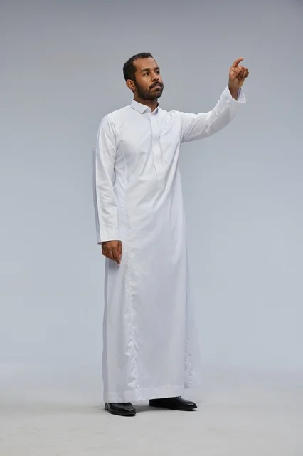 Saudi Man in White Thobe Pointing in Studio Background
