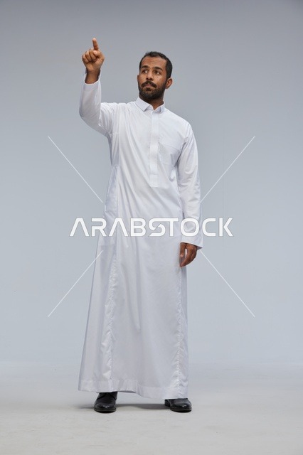 رجل سعودي يرتدي الثوب الأبيض يشير بإصبعه