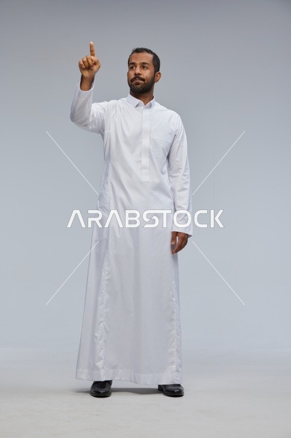 رجل سعودي بالثوب الأبيض يشير بإصبعه في الاستوديو