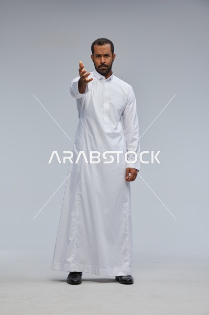 Saudi Man in White Thobe Gesturing in a Studio Setting
