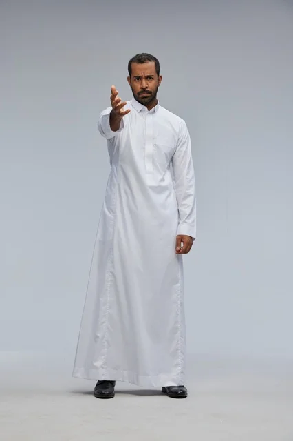 Saudi Man in White Thobe Gesturing in a Studio Setting