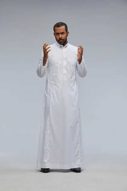 رجل سعودي يرتدي الثوب الأبيض بتعابير وجه غاضبة في الاستوديو