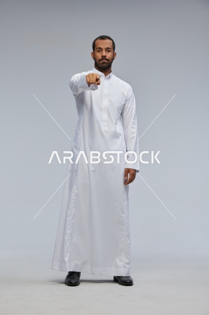 Saudi Man in White Thobe Pointing at Camera