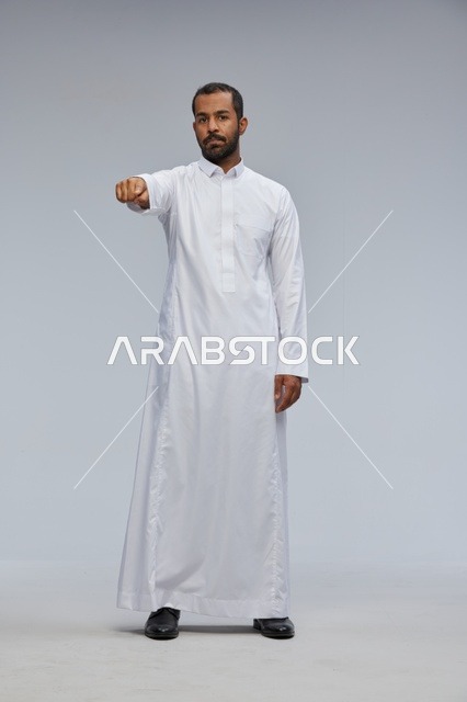 Saudi Man in White Thobe Pointing at Camera Studio