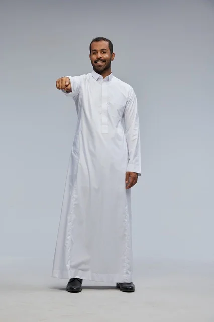 Smiling Saudi Man in White Thobe Pointing at Camera
