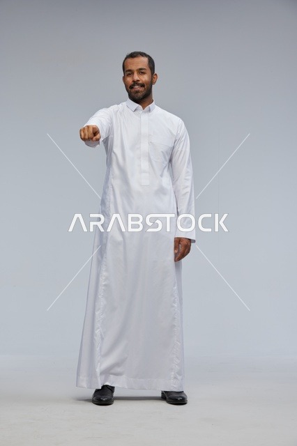 Saudi Man in White Thobe Pointing at Camera