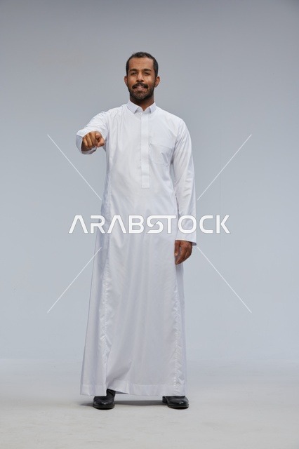 رجل سعودي بالثوب الأبيض يشير نحو الكاميرا
