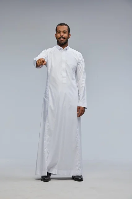 رجل سعودي بالثوب الأبيض يشير نحو الكاميرا