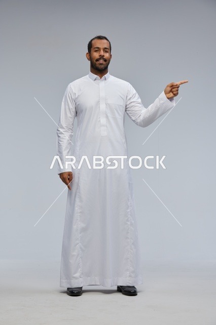 Saudi Man in White Thobe Pointing Side in Studio