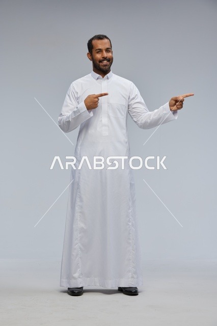 رجل سعودي بالثوب الأبيض يشير بيده في الاستوديو