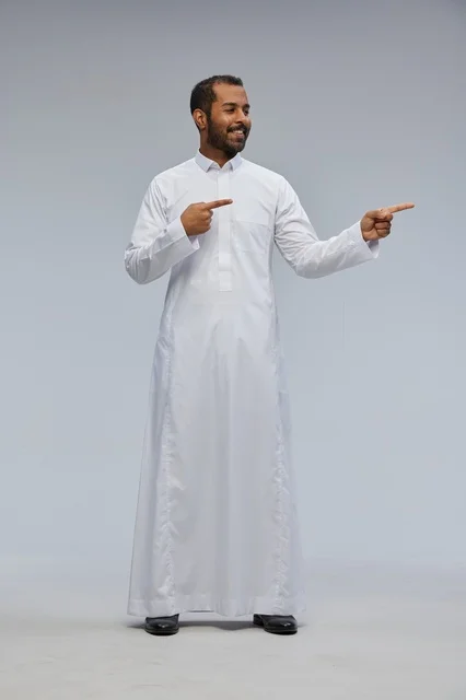 Saudi Man in White Thobe Pointing at Copy Space