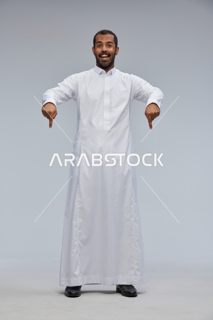 Saudi Man in White Thobe Pointing Down in Studio