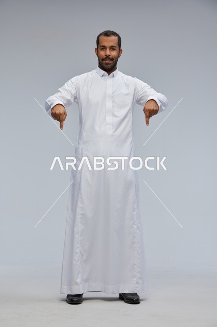 Saudi Man in White Thobe Pointing Down Studio Shot