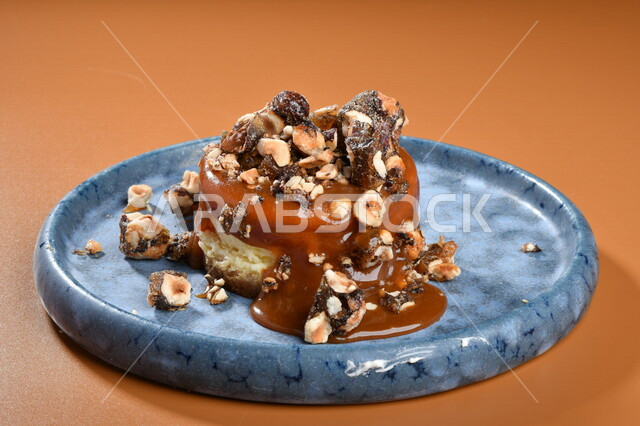 طبق من الحلا البارد مزين بالكراميل والبندق اللذيذ ، حلا شرقي ، حلويات رمضانية ، حلويات وسكريات ، قطع الحلوى الشهية ، التحلاية ، حلويات باردة لذيذة