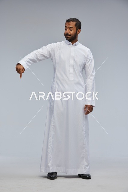 Saudi Man in White Thobe Pointing Down in Studio