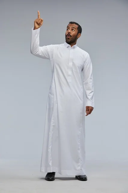 رجل سعودي بالثوب الأبيض يشير للأعلى في استوديو