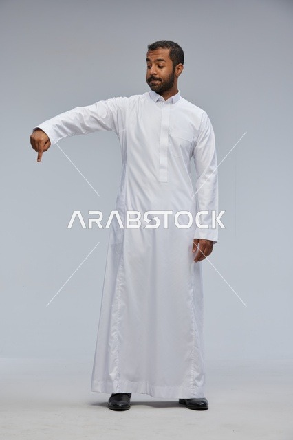 Saudi Man in White Thobe Pointing Down in Studio
