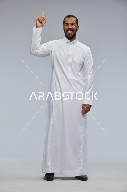 Saudi Man in Traditional White Thobe Pointing Upward