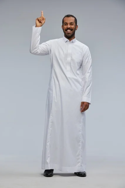 رجل سعودي يرتدي الثوب التقليدي يشير بإصبعه للأعلى
