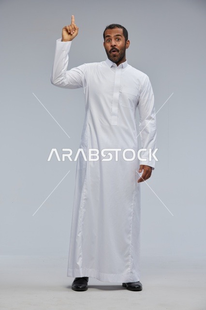 رجل سعودي بالثوب الأبيض يشير للأعلى بتعبير مندهش