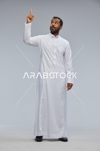 Saudi Man in White Thobe Pointing Upwards Studio Shot