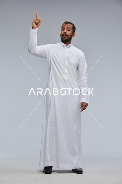 Saudi Man in Traditional White Thobe Pointing Upwards Studio