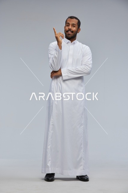 رجل سعودي بالثوب الأبيض يشير بإصبعه للأعلى