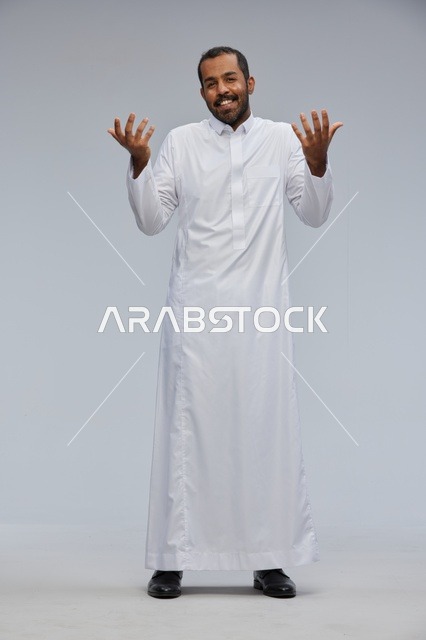 رجل سعودي بالثوب الأبيض يقوم بإيماءات في الاستوديو