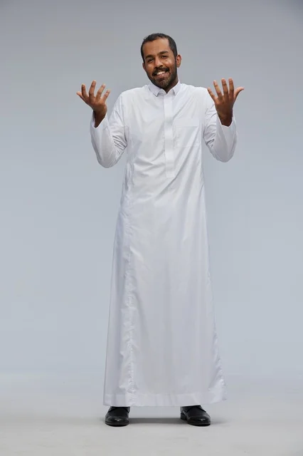 Saudi Man in White Thobe Gesturing on Gray Background