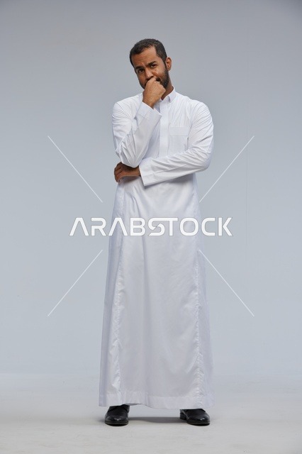 رجل سعودي بالثوب الأبيض بوضعية تفكير في الاستوديو