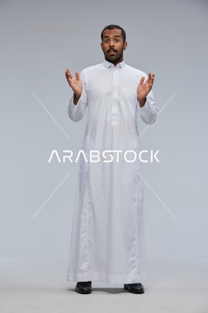 رجل سعودي يرتدي ثوباً أبيض بتعبيرات وجه مندهشة
