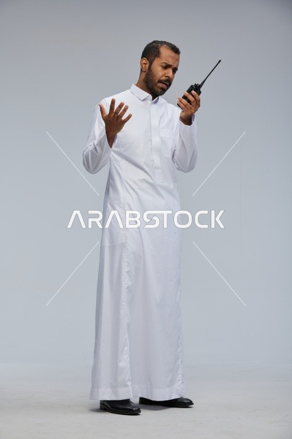 Saudi Man in White Thobe Using Walkie Talkie in Studio