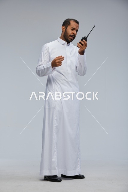 Saudi Man in White Thobe Using Walkie Talkie in Studio