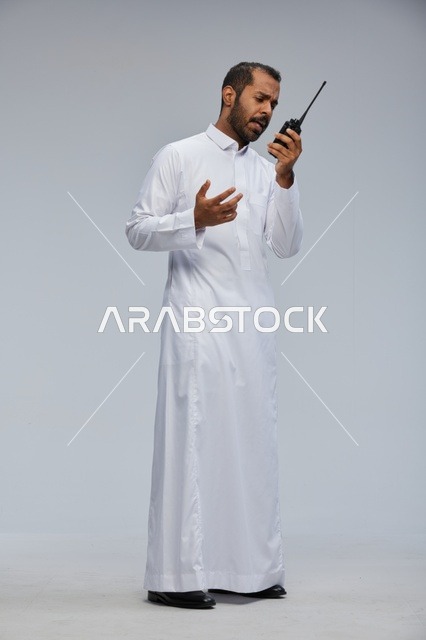 Saudi Man in White Thobe Using Walkie Talkie Radio