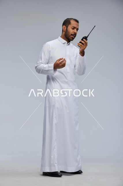 Saudi Man in White Thobe Using Wireless Radio Studio