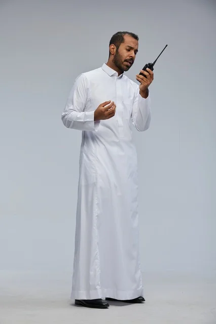 Saudi Man in White Thobe Using Wireless Radio Studio
