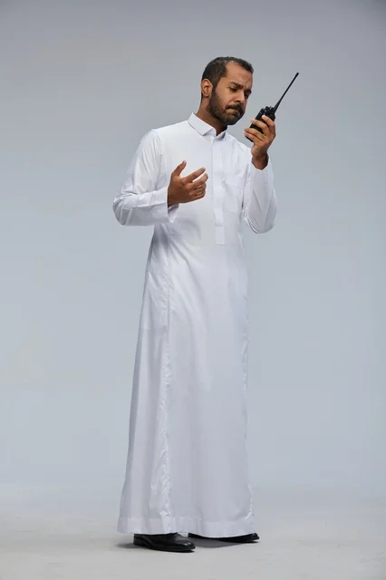 Saudi Man in White Thobe Using Walkie-Talkie Radio