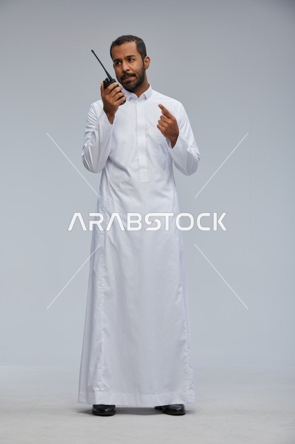 Saudi Man in White Thobe Using Walkie Talkie Radio
