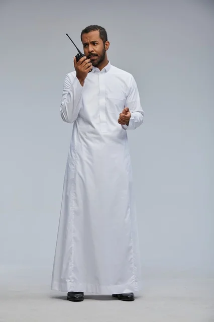 Saudi Man in White Thob Using Walkie Talkie